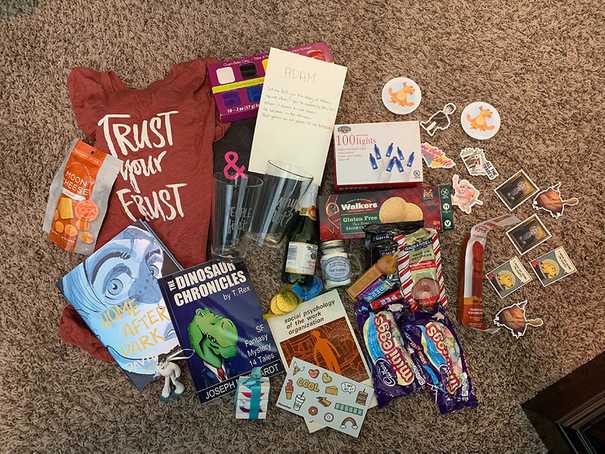 a spread of gifts including books, snacks, tshirts, and stickers.