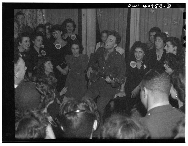 Pete in Army uniform surrounded by people singing, 1941